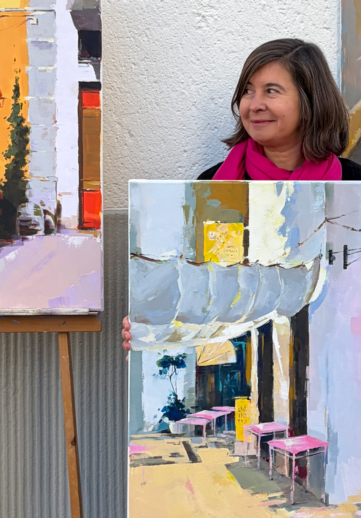 Grażyna Ostrowska holding one of her large Algarve-inspired paintings, introducing herself as the host of Lighthouse Artcourses.