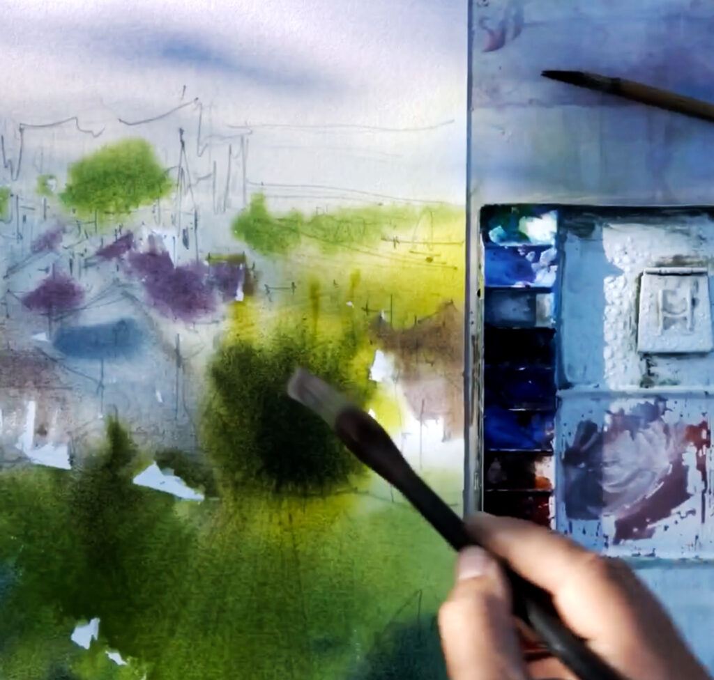 Close-up of hands painting a watercolour landscape surrounded by greenery in Algarve